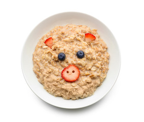 Plate with creative oatmeal for children on white background