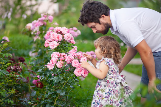 Adorable Toddler Girl Smelling Flowers.