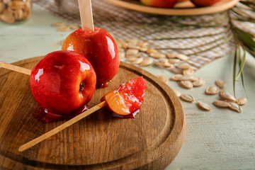 Tasty candy apples on wooden board