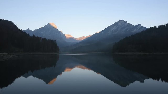 Peaceful autumn view on Obersee lake in Swiss Alps. Clear sky and mountains reflections in clear water. Nafels village, Switzerland. Timelapse video