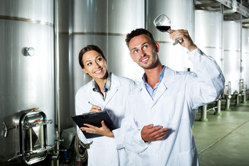 Obraz premium Winery workers taking notes while discussing wine sample