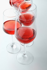 Glasses of sweet wine on white background