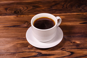 Cup of dark coffee on wooden table