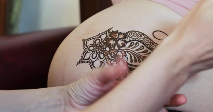 Drawing a mehendi on the stomach