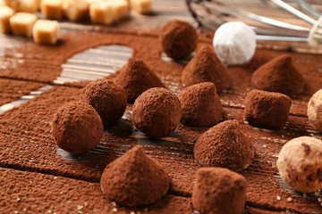 Tasty chocolate truffles powdered with cacao on table