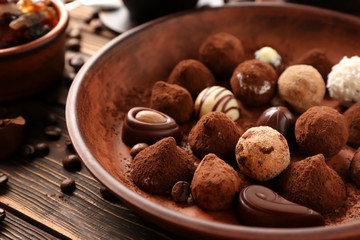 Plate with tasty chocolate truffles on table, closeup