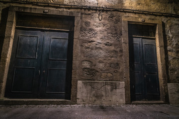Plakat couple of doors in a dark street at night