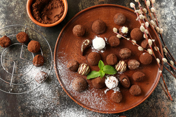 Plate with tasty chocolate truffles  on dark table