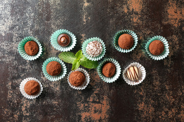 Different tasty chocolate truffles on dark table
