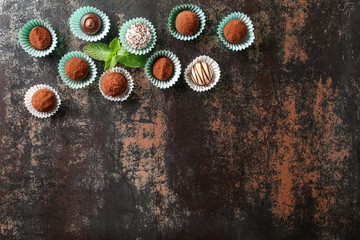 Different tasty chocolate truffles on dark table