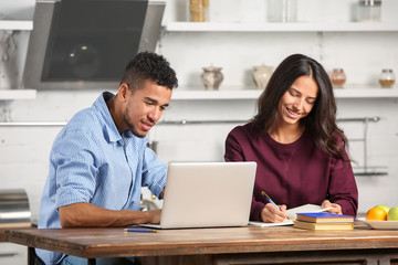 Young couple with laptop in kitchen