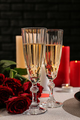 Glasses of champagne with red roses on festive table. Valentines Day celebration