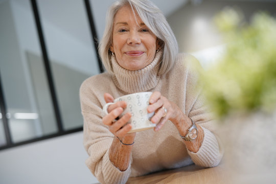  Senior woman at home with hot drink