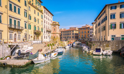 Fototapeta na wymiar Buildings, canals and boats in the Little Venice district of Livorno, Tuscany, Italy. The Venice quarter is the most charming and picturesque part of the city