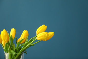 Vase with beautiful tulips on color background