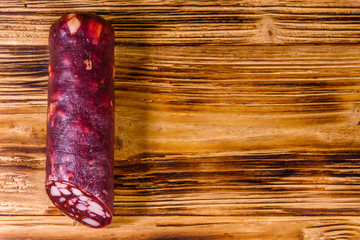 Smoked salami sausage on a wooden table. Top view