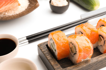 Tasty sushi rolls on white background