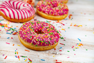 Pink donuts on a wooden background.