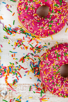 Pink donuts on a wooden background.