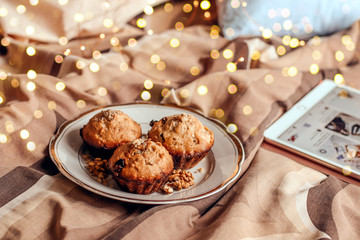 Delicious fresh cupcakes with chocolate on a plate in bed. 