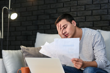 Tired young man with a lot of paperwork at home © Pixel-Shot