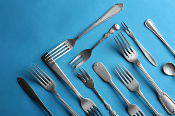 Silver cutlery on colour background