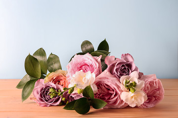 Beautiful bouquet of roses on wooden table