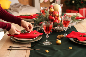 Woman setting the table for Christmas dinner