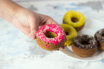 pink donut on a female hand