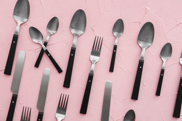 Spoons and forks on color background, flat lay