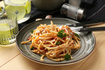 Plate with delicious pasta on wooden table, closeup