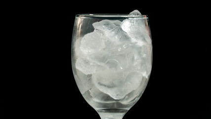 Ice in a glass with black background.