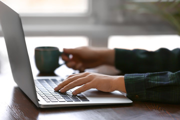 Woman using computer at wooden table