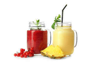 Mason jars with tasty fruit smoothies on white background