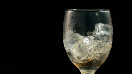 sparkling water is dilute with ice on black background.