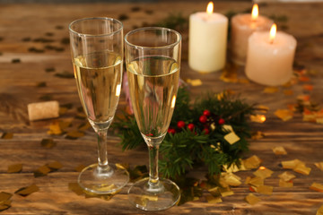 Glasses of champagne with burning candles on wooden table