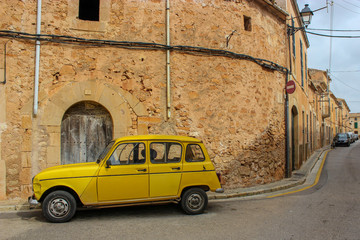 Geles Auto vor rustikaler Mauer