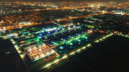 Widok z lotu ptaka uzdatniania wody roślina przy nocą z pejzażem miejskim dla środowiska pojęcia. - 237213984