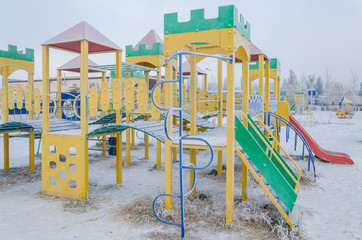 Fototapeta na wymiar Children's playground covered with snow in winter