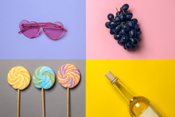 Sunglasses, ripe grapes, lollipops and bottle of wine on color background