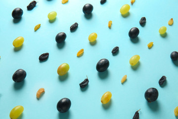 Grapes with raisins on color background