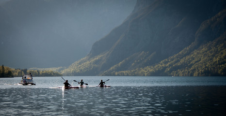 People canoeing on the Lake Bohinj on a spring morning in Slovenia. Picturesque landscape!