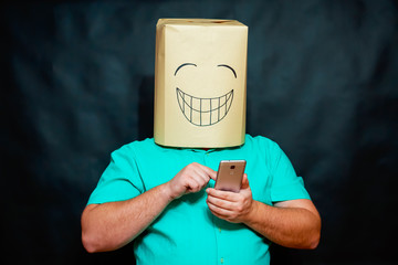 The concept of emotions. A man with a happy expression on his face dials the number on the smartphone.