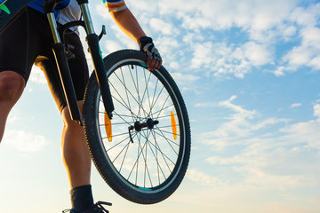 Naklejka premium man bicyclist in trouble of front wheel of bicycle on the road, needs repairing