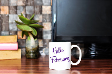 Hello February written on white coffee cup concept