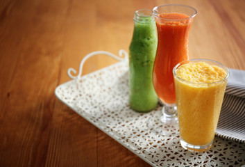 Glassware of tasty smoothies on wooden table