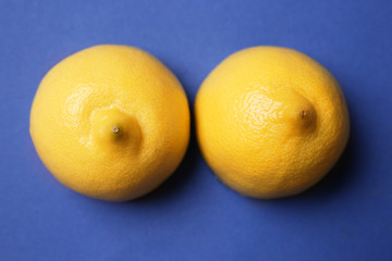 Fresh juicy lemons on color background. Erotic concept