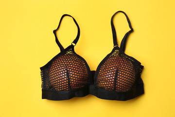 Ripe grapefruits in bra on color background