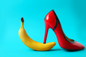 High heel shoe and banana on color background. Erotic concept
