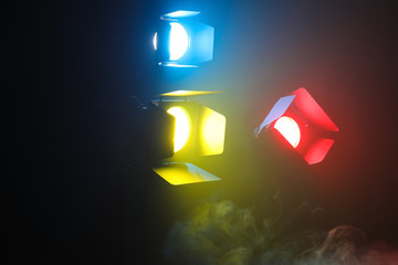 Professional color lighting equipment with fume on dark background